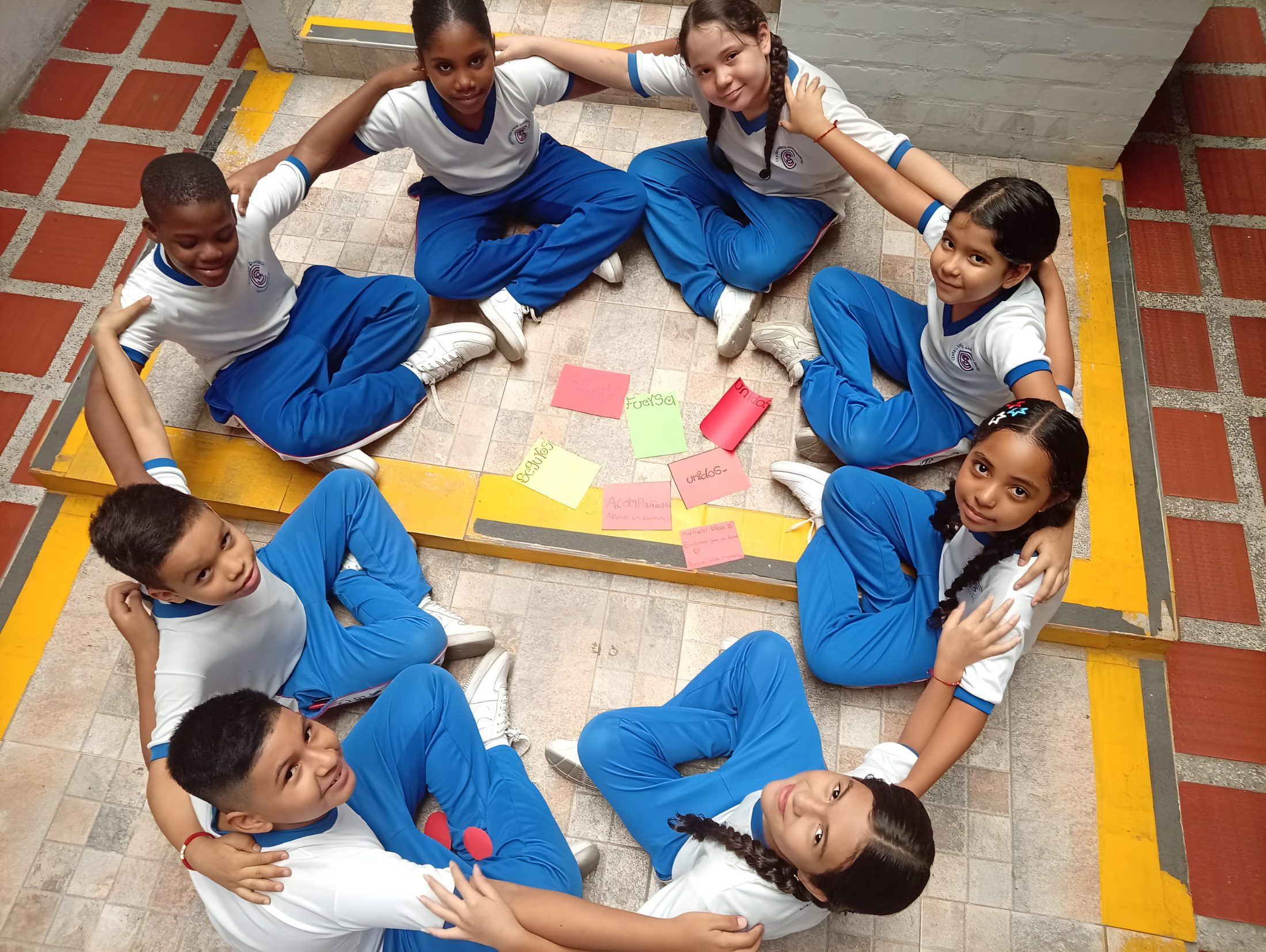 Estudiantes trabajando en círculo con notas de colores